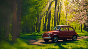 fiat 500 d'epoca di colore rosso in un lussureggiate bosco con fiori rosa e prati verdi